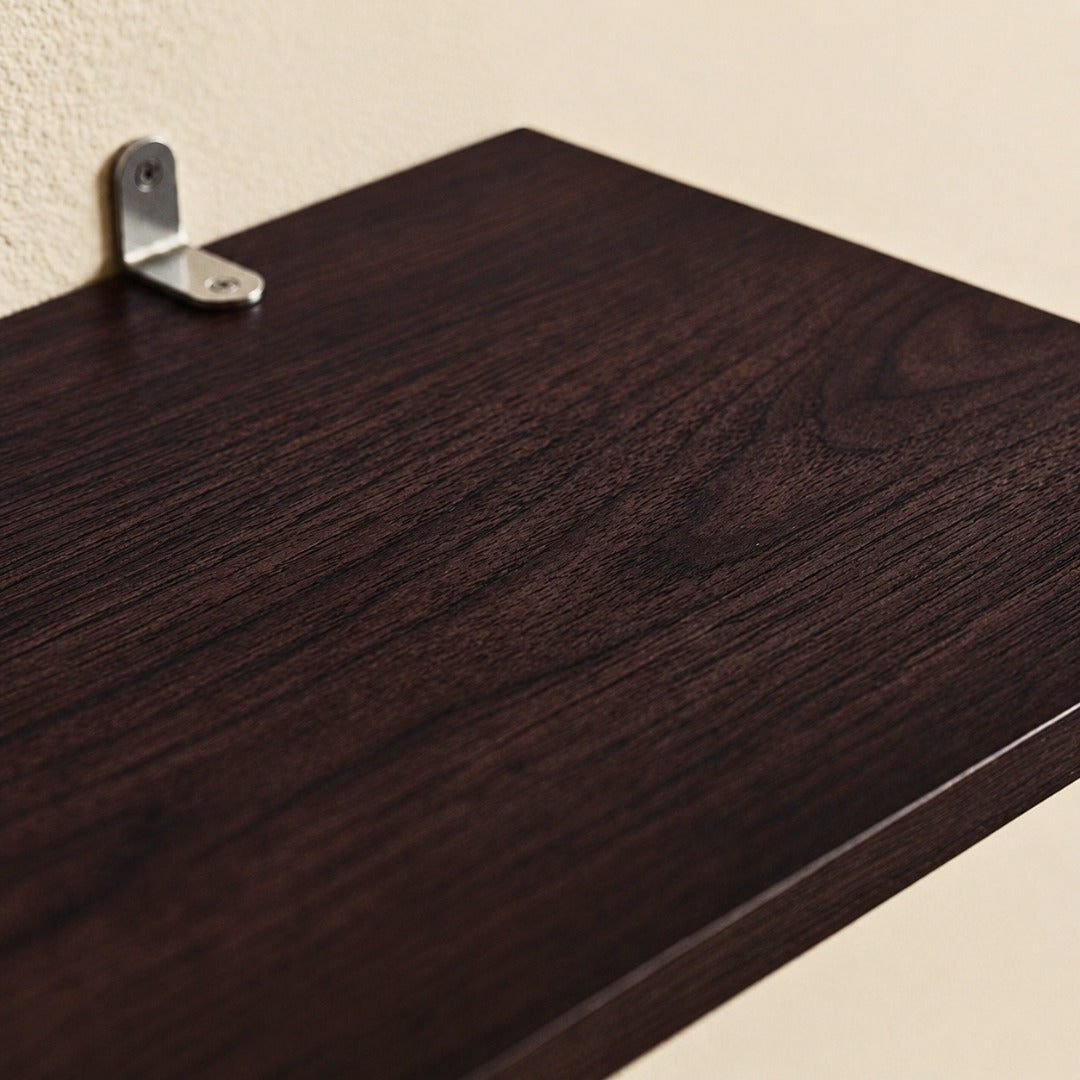 Dark brown wood wall shelf with a visible metal mounting bracket attached to a textured beige wall.